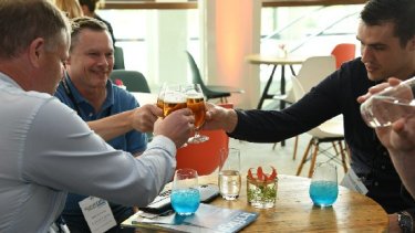 A group of people talking and drinking beverages at the event
