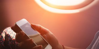 A person looks at a smartphone onboard an airplane