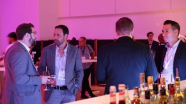 A group of people talking and drinking beverages at the event