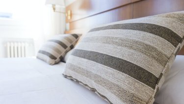 A pillow rests on a hotel bed.