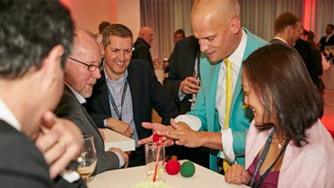 man in a green suit performing magic tricks at WTCE event